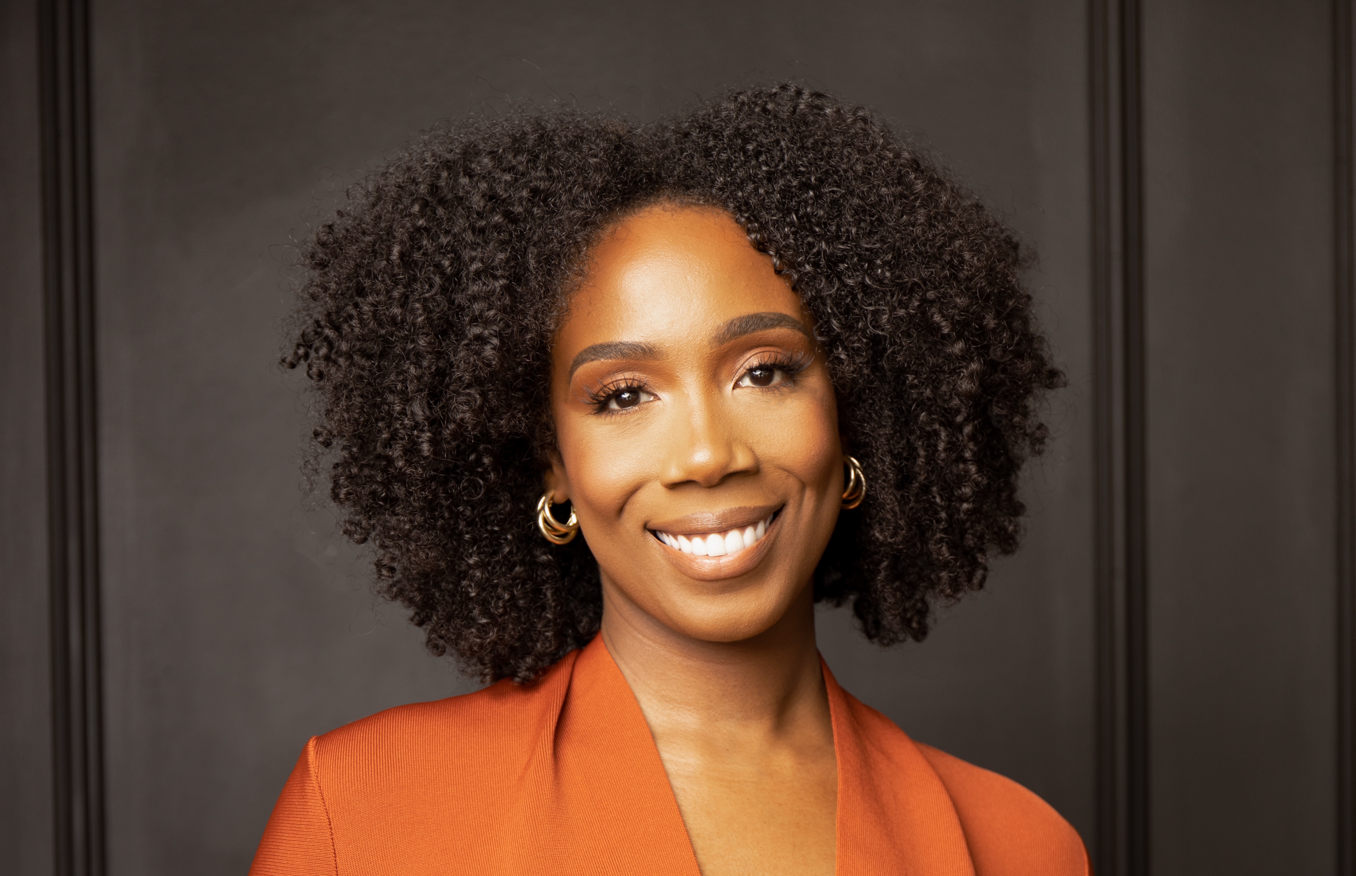 Portrait of Cierra Gross smiling, wearing gold hoop earrings